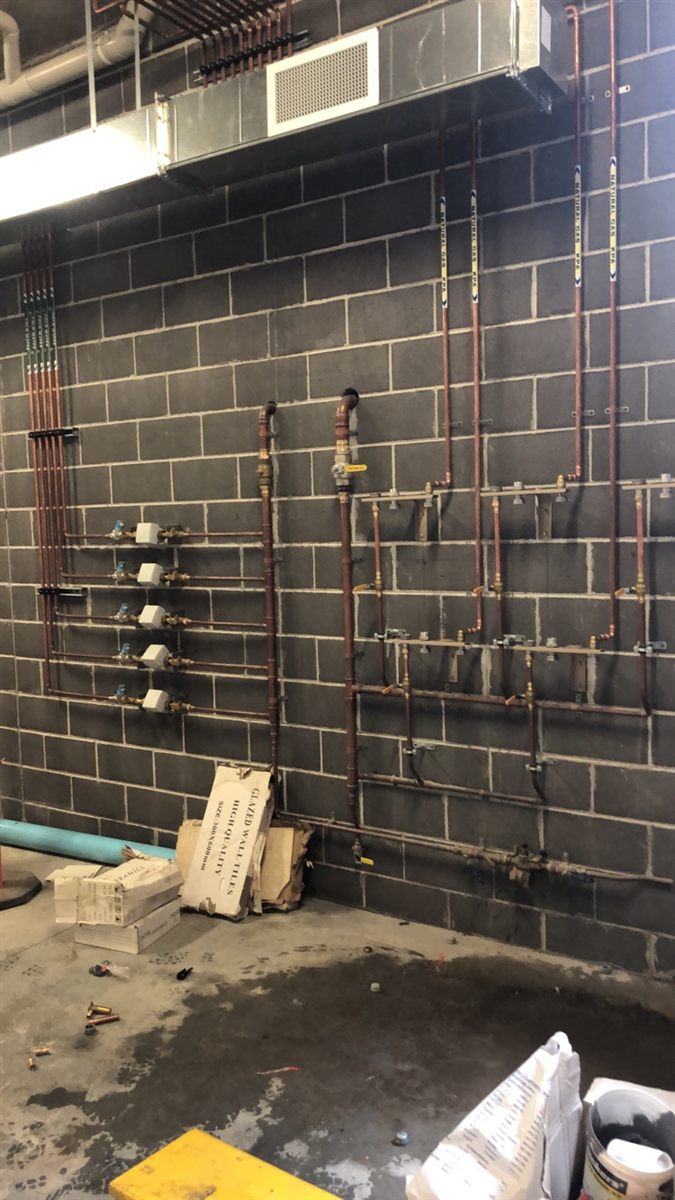 Copper gas and water manifolds on a block wall